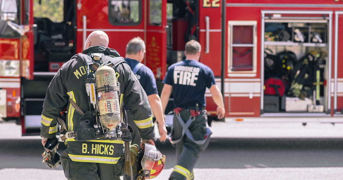 Fire fighters walk toward fire truck