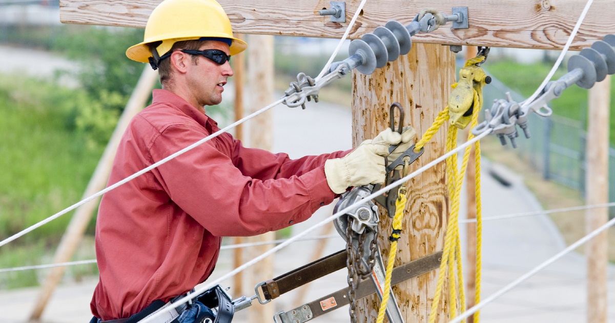 Utility lineman works on power pole