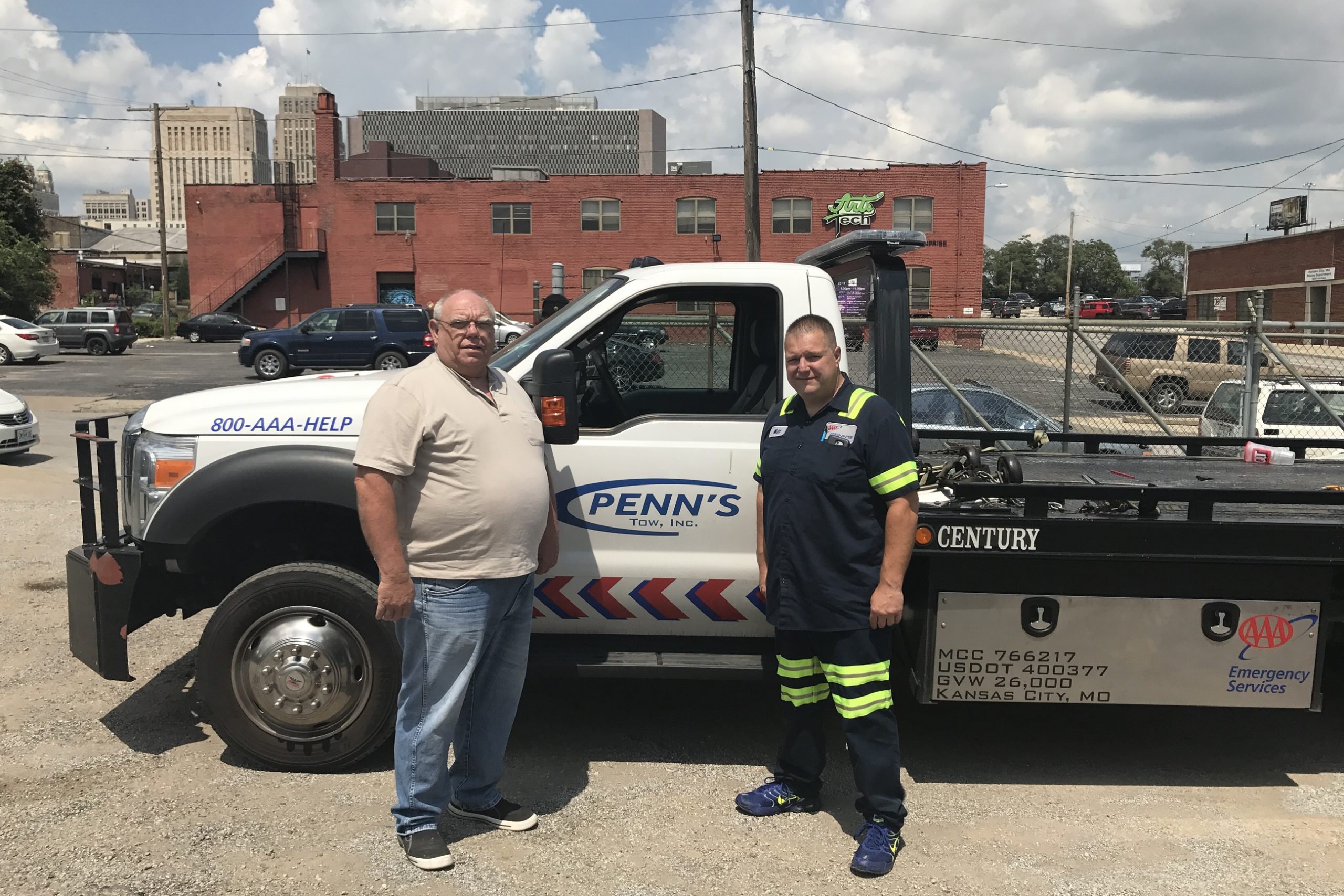 Bill Penn and driver standing beside tow truck