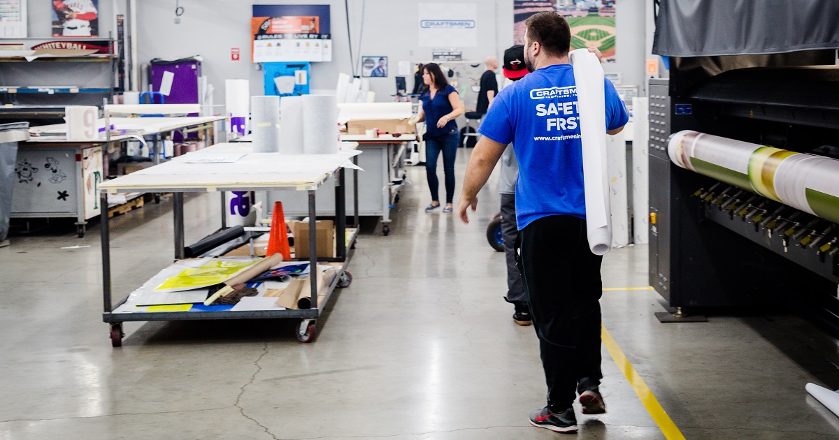 Worker carries material in manufacturing facility