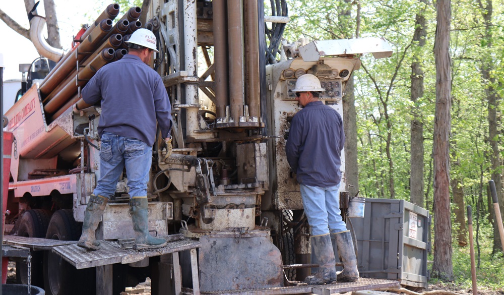 Flynn Drilling employees work with a drill